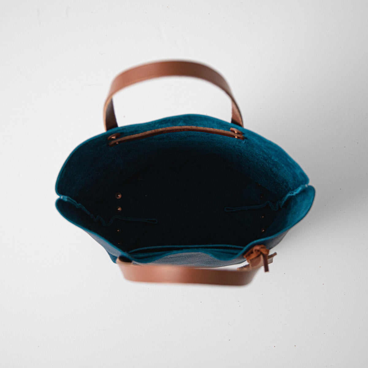 Handmade Petrol Blue Bison leather tote bag featuring a spacious interior, natural grain texture, and durable tan leather handles.