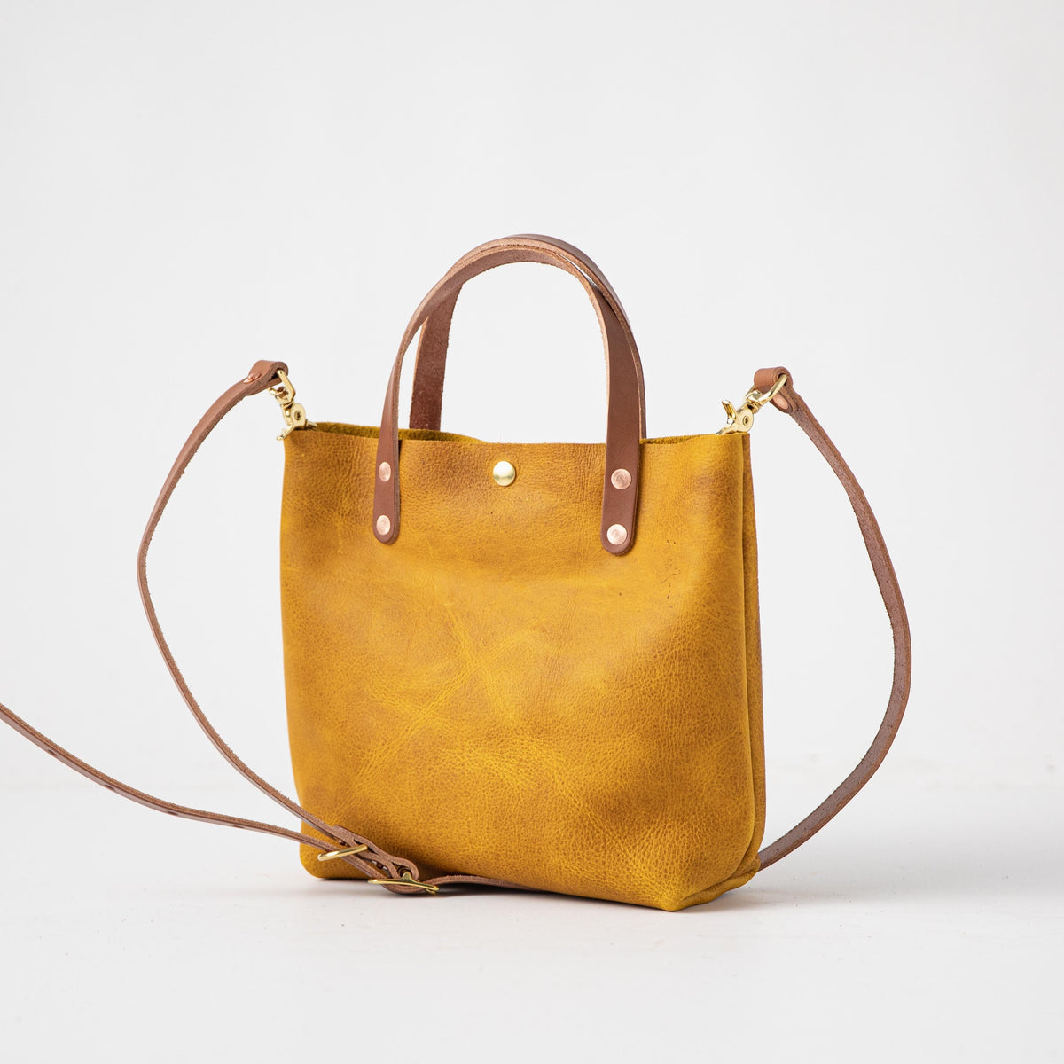 Handmade Yellow Bison Mini Tote, a vibrant full-grain leather bag with tan handles and a detachable shoulder strap.