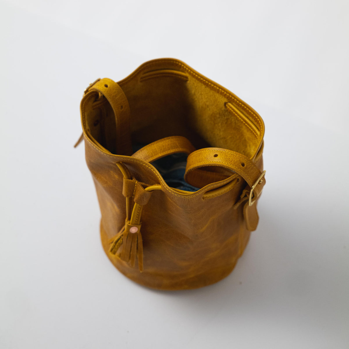 Vibrant Yellow Bison full-grain leather bucket bag with prominent grain, soft temper, and adjustable strap.
