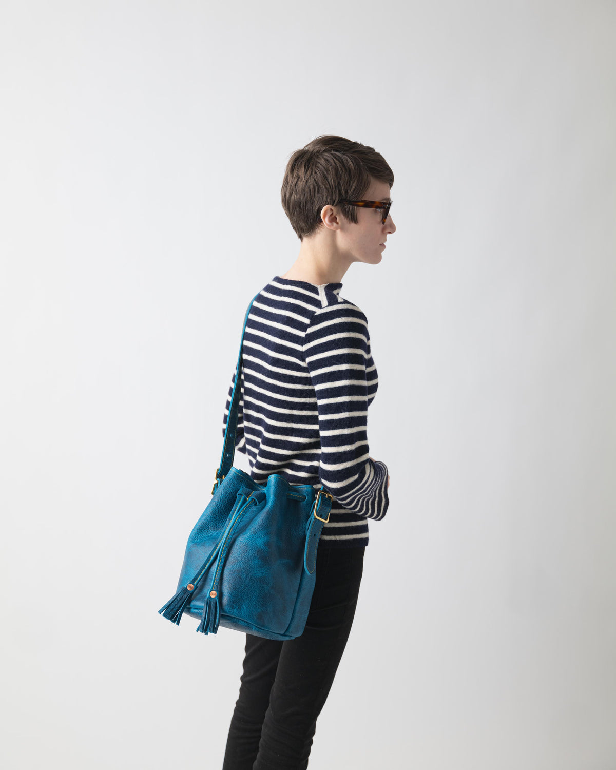 Petrol Blue Bison Bucket Bag with elegant leather tassels and a comfortable crossbody strap.