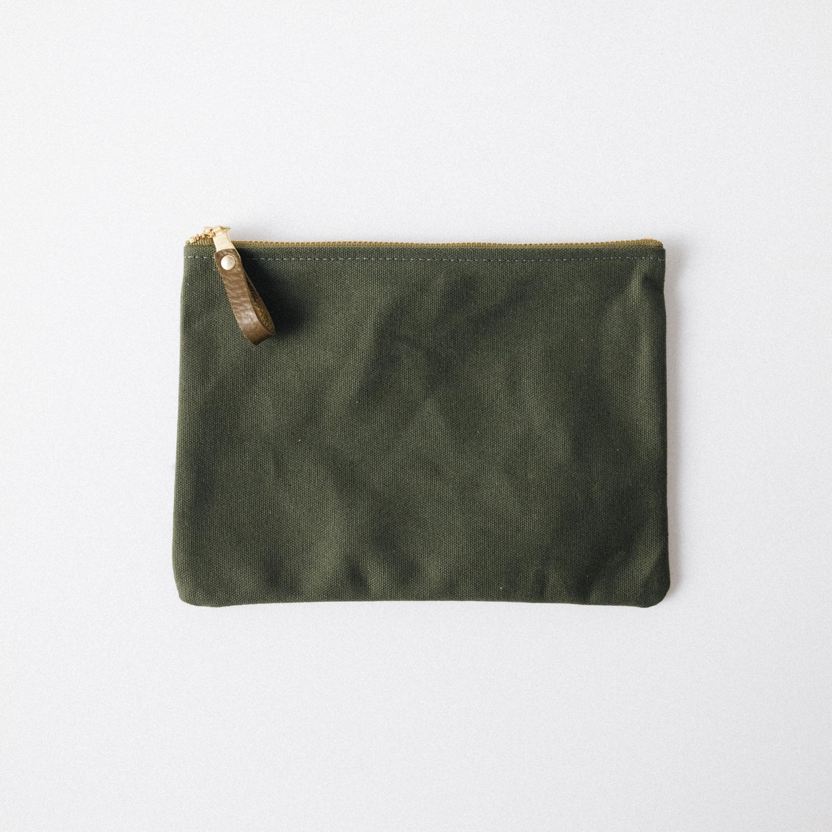 Olive green heavyweight cotton canvas zip pouch with a solid brass zipper and leather pull.