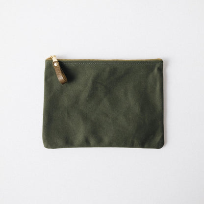 Olive green heavyweight cotton canvas zip pouch with a solid brass zipper and leather pull.