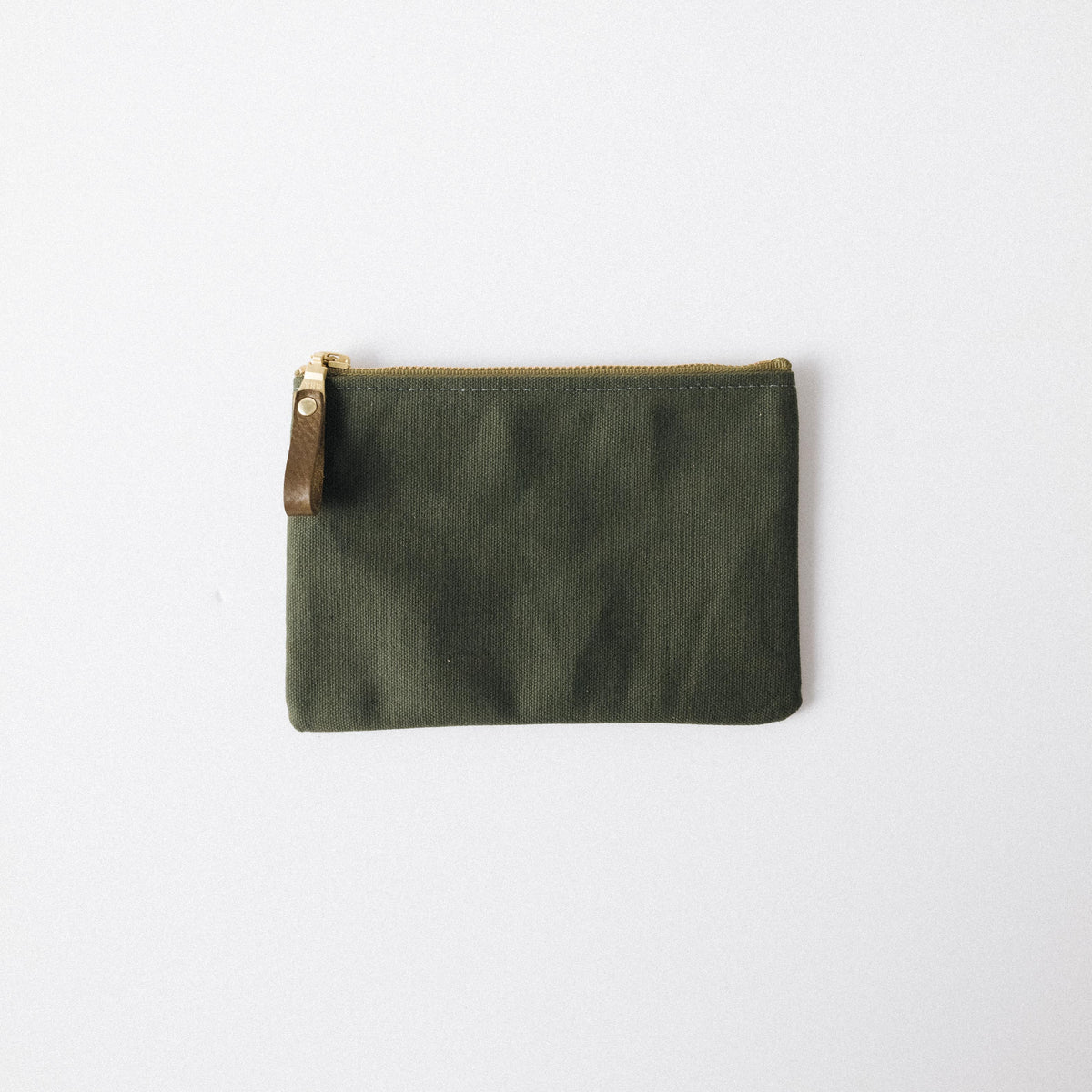 Olive green heavyweight canvas zip pouch with a solid brass zipper and brown leather pull for easy organization.