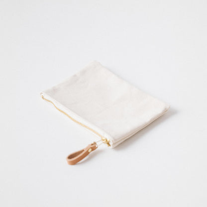 Handmade heavyweight cotton canvas zip pouch with a solid brass zipper and tan leather pull for easy organization.