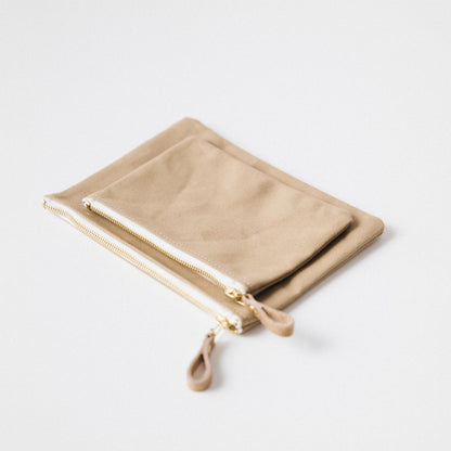 Two tan heavyweight cotton canvas zip pouches with solid brass zippers and leather pulls.