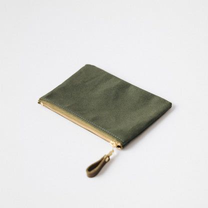 Olive green heavyweight cotton canvas zip pouch with a solid brass zipper and leather pull for easy organization.