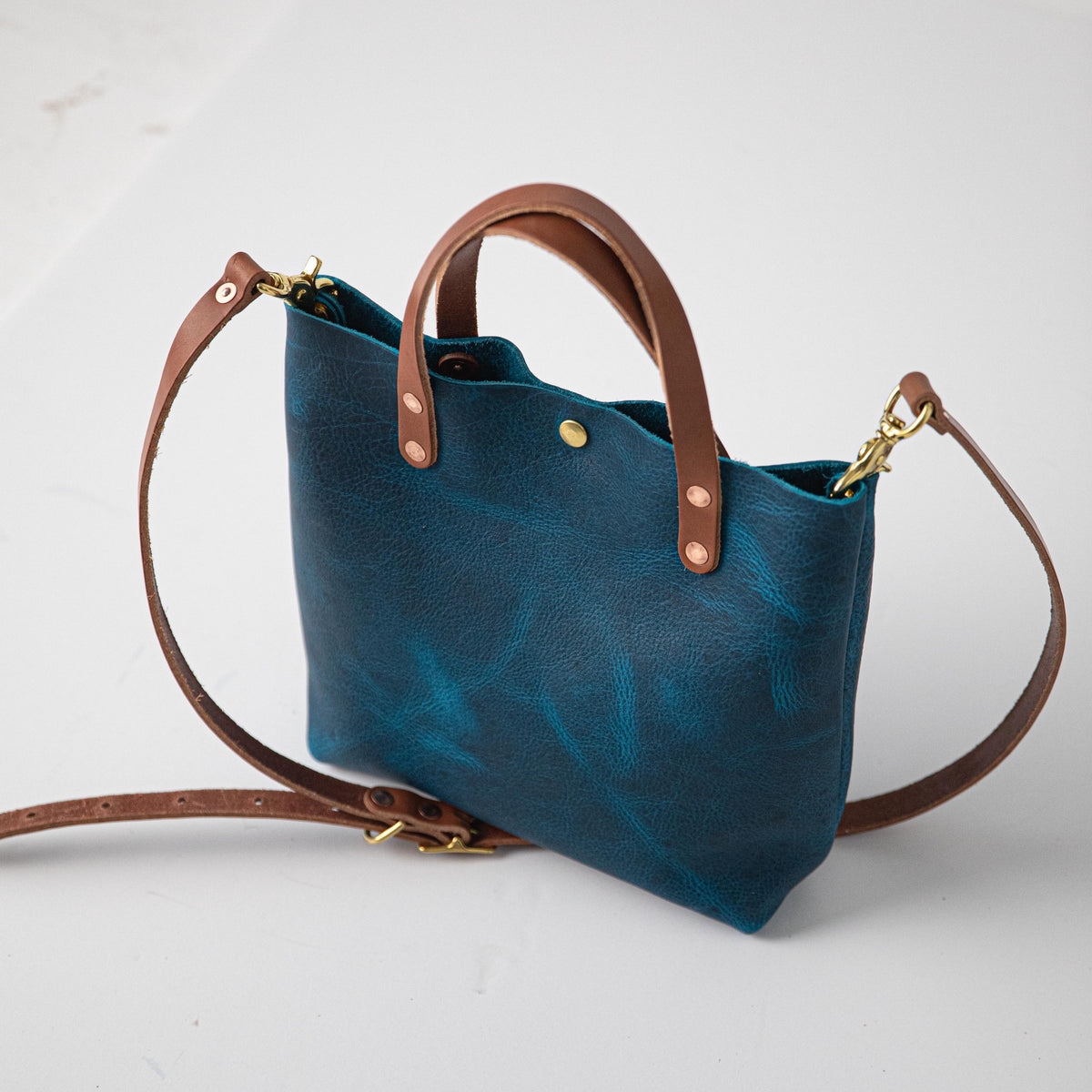 Petrol Blue Bison Mini Tote: vibrant blue full-grain leather, tan handles, and a detachable shoulder strap.