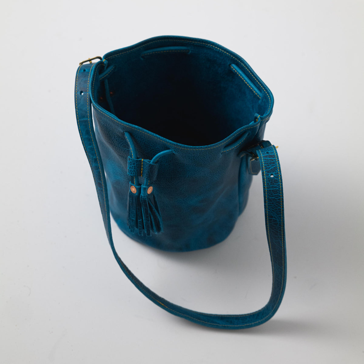 Petrol Blue Bison Bucket Bag with elegant leather tassels and a comfortable strap.