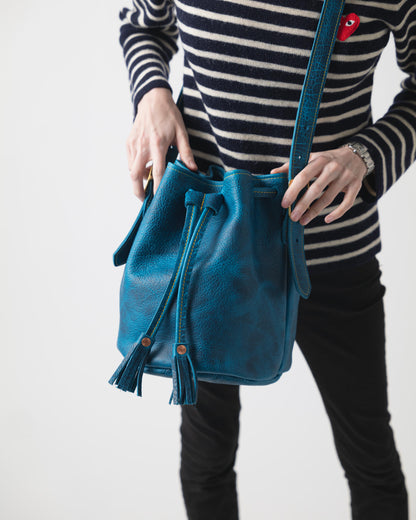 Petrol Blue Bison Bucket Bag: luxurious leather with playful tassels, drawstring closure, and comfortable strap.
